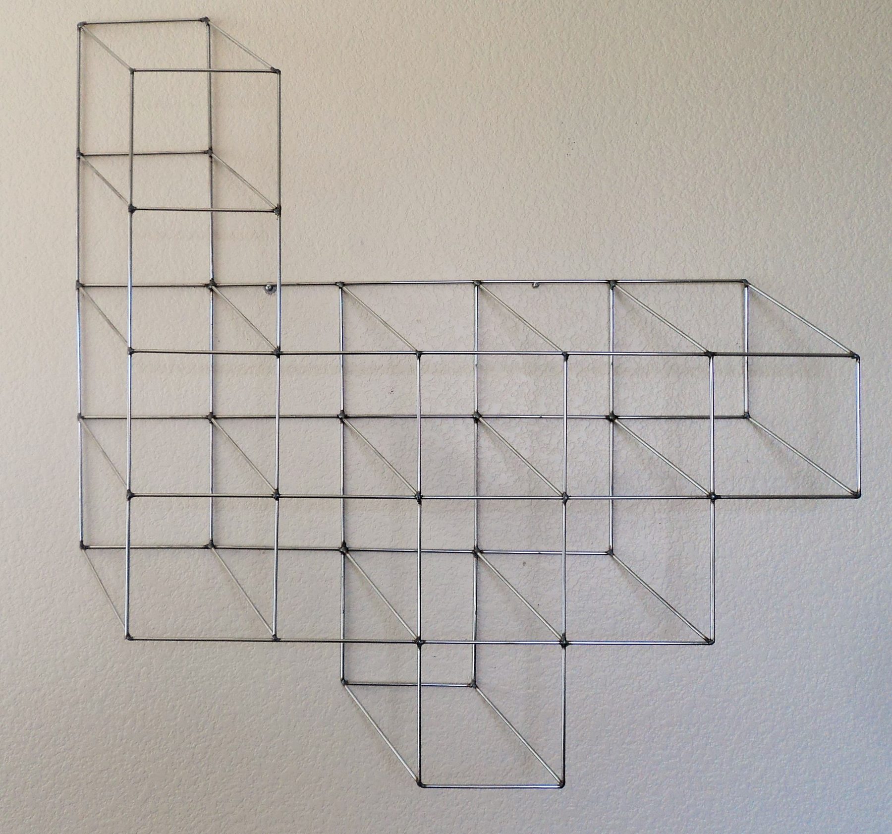 Welded geometric metal wall sculpture with copper accents