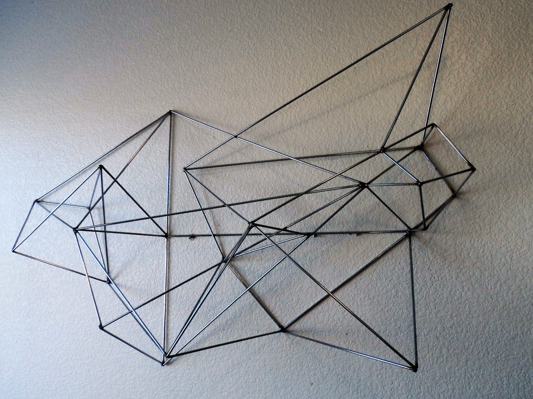 Layered geometric welded metal wall sculpture