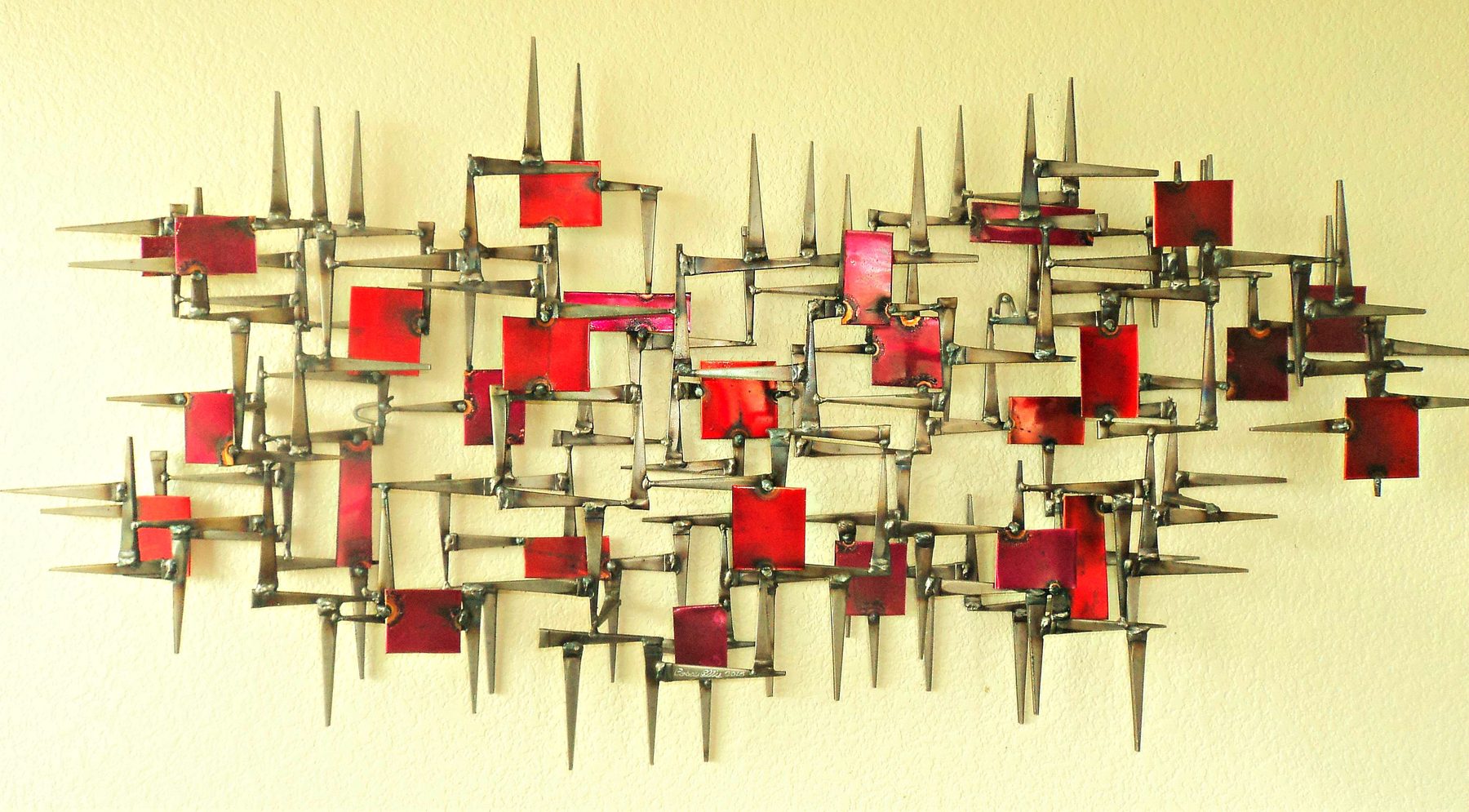 Mid-century influenced welded metal wall sculpture in warm brass tones Mid-century influenced welded metal wall sculpture in warm brass tones