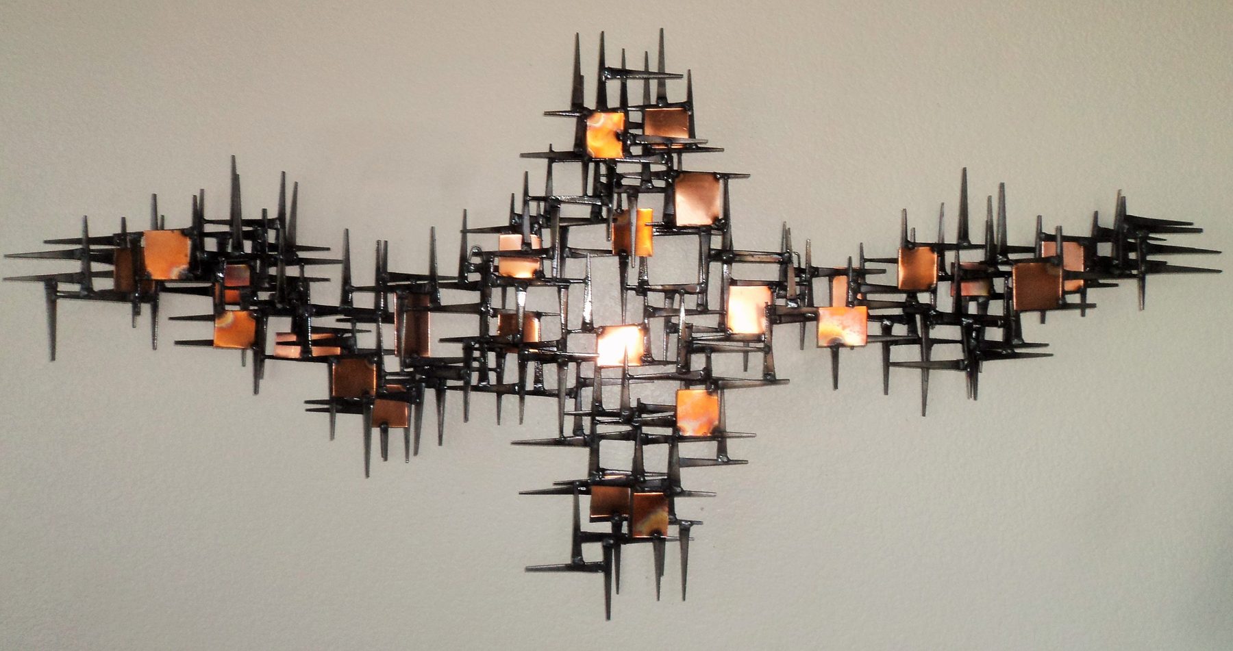 Atomic-era inspired brass and steel wall sculpture