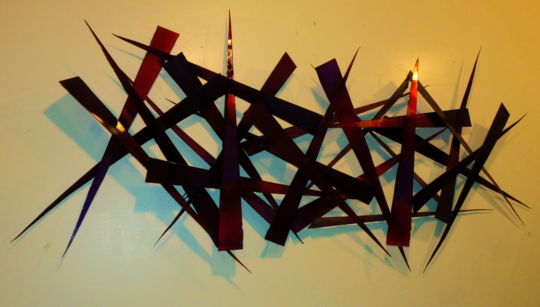 Breaking Charity - large-scale welded steel wall sculpture by Corey Ellis with red and amber patina